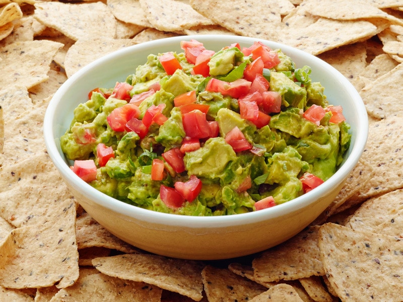 Plate of tomato studded guacamole with scallions and chili