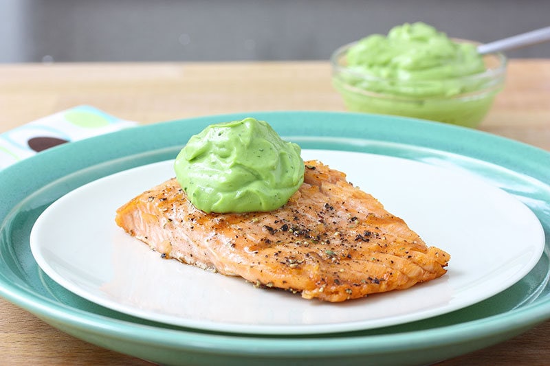 Plate of salmon topped off with avocado sauce